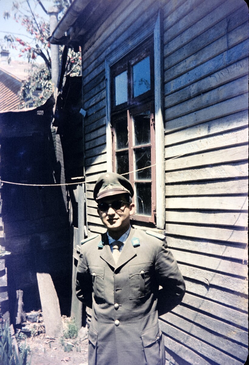 Retrato de plano medio de Hombre con uniforme de carabinero posando de frente en el patio de una casa