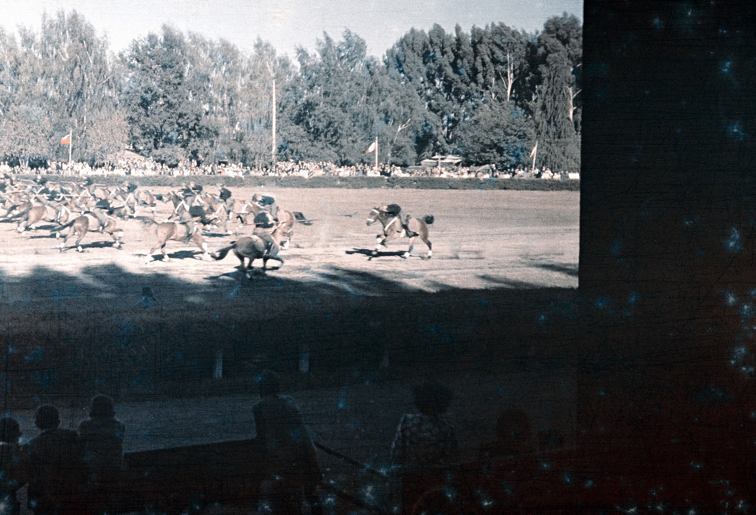 Plano general de un grupo de hombres uniformados a caballo portando banderines visto desde el sector de las gradas