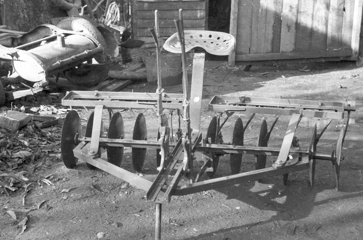 plano general de artefacto que se engancha en tractor para arar la tierra, tiene un asiento para que alguien vaya dirigiendo.