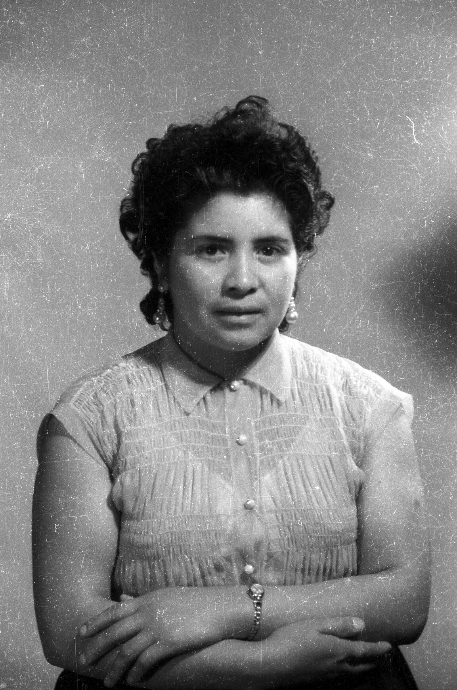 Retrato de estudio de Plano medio de una mujer de pelo corto, posando de frente con los brazos cruzados