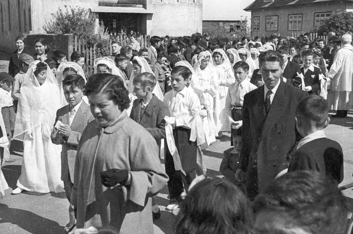 plano general de un grupos de Niñas y Niños formados en dos hileras. En el fondo un sacerdote está parado esperando que salgan todos de la parroquia inmaculada concepción.