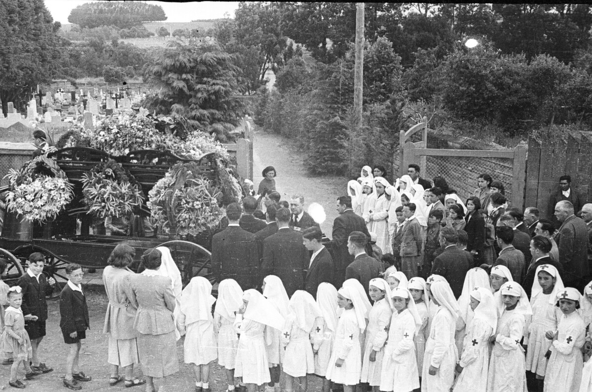 Plano general de niños y niñas, Hombres y mujeres en un cortejo fúnebre