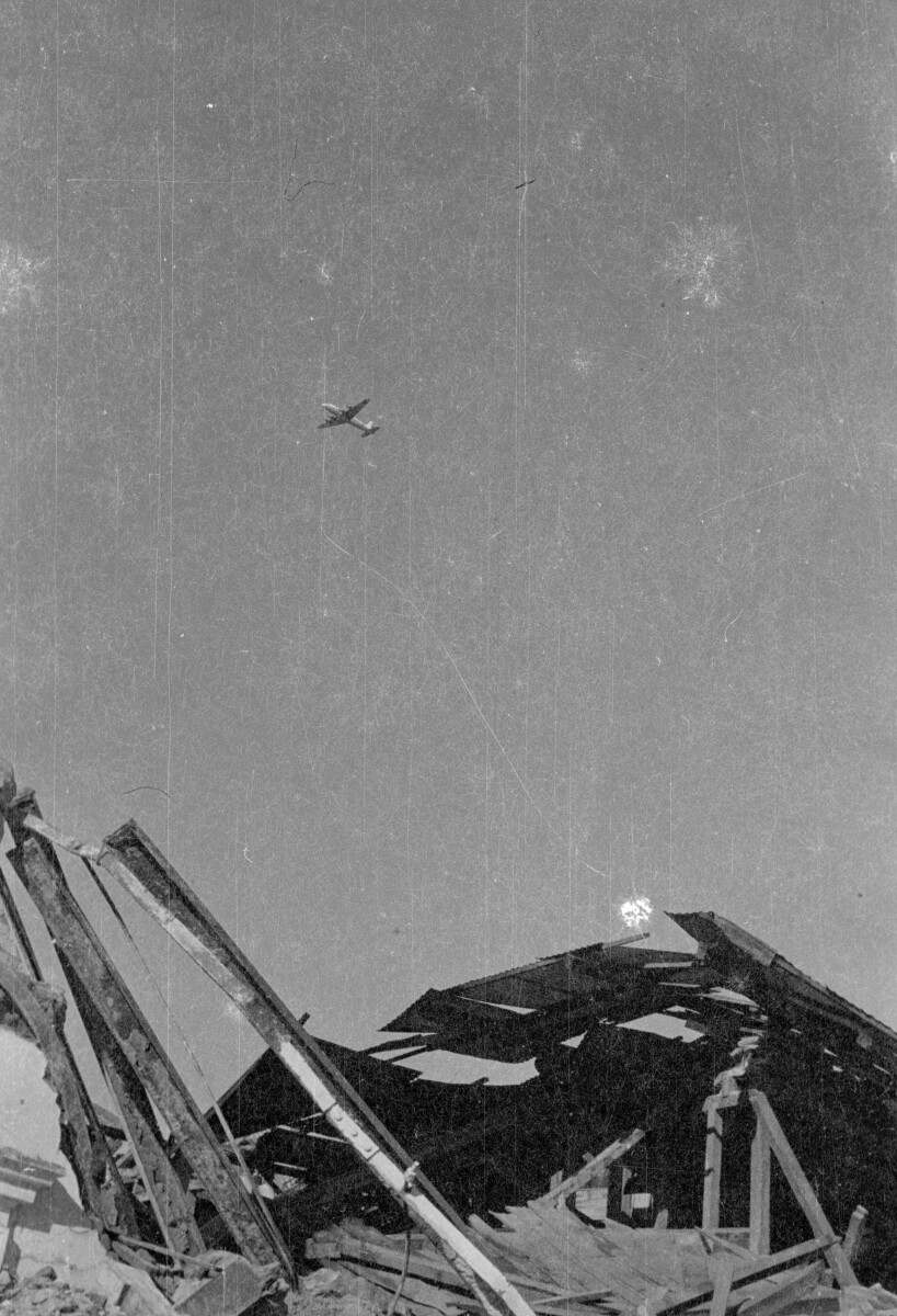 Plano entero de avión sobrevolando infraestructura derrumbada por el terremoto del 60', Valdivia