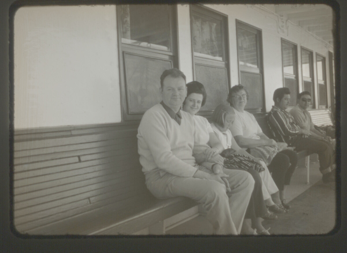 Retrato de plano entero de Gonzalo Carrasco, Marta Walburg, Yelly Carrasco y Paulina Sandoval sentados en una estación de ferrocarriles