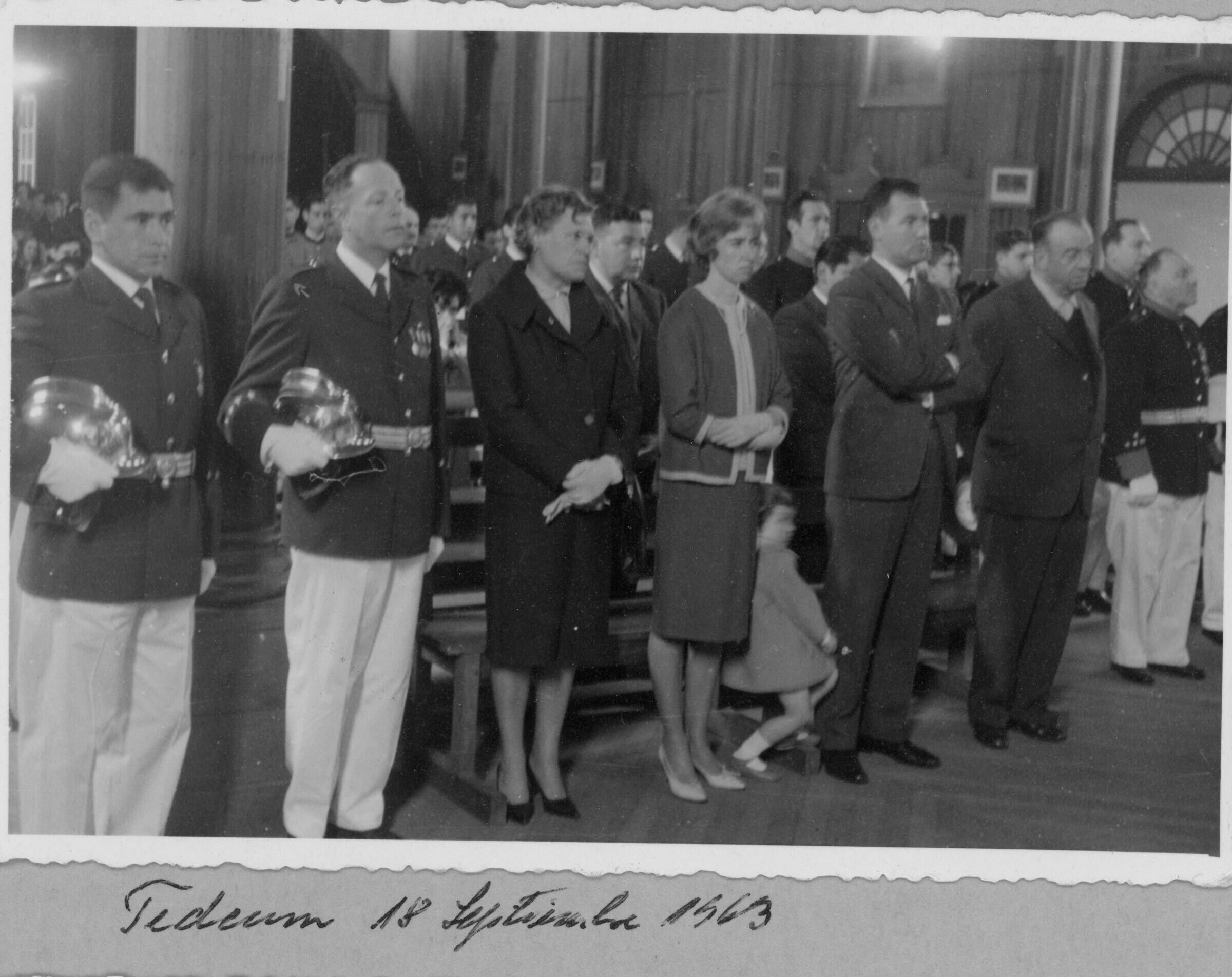 Plano entero de Olga Boettcher, Enrique Larre junto a su señora y su hija María Elena Larre, parados en primera fila. Se encuentran en el interior de la parroquia San José durante el Te Deum de fiestas patrias