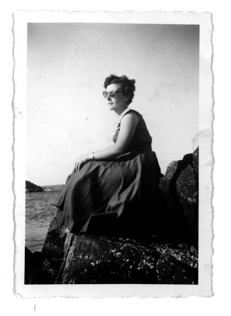 Mujer con gafas de sol sentada en las rocas de la Playa Pichidangui