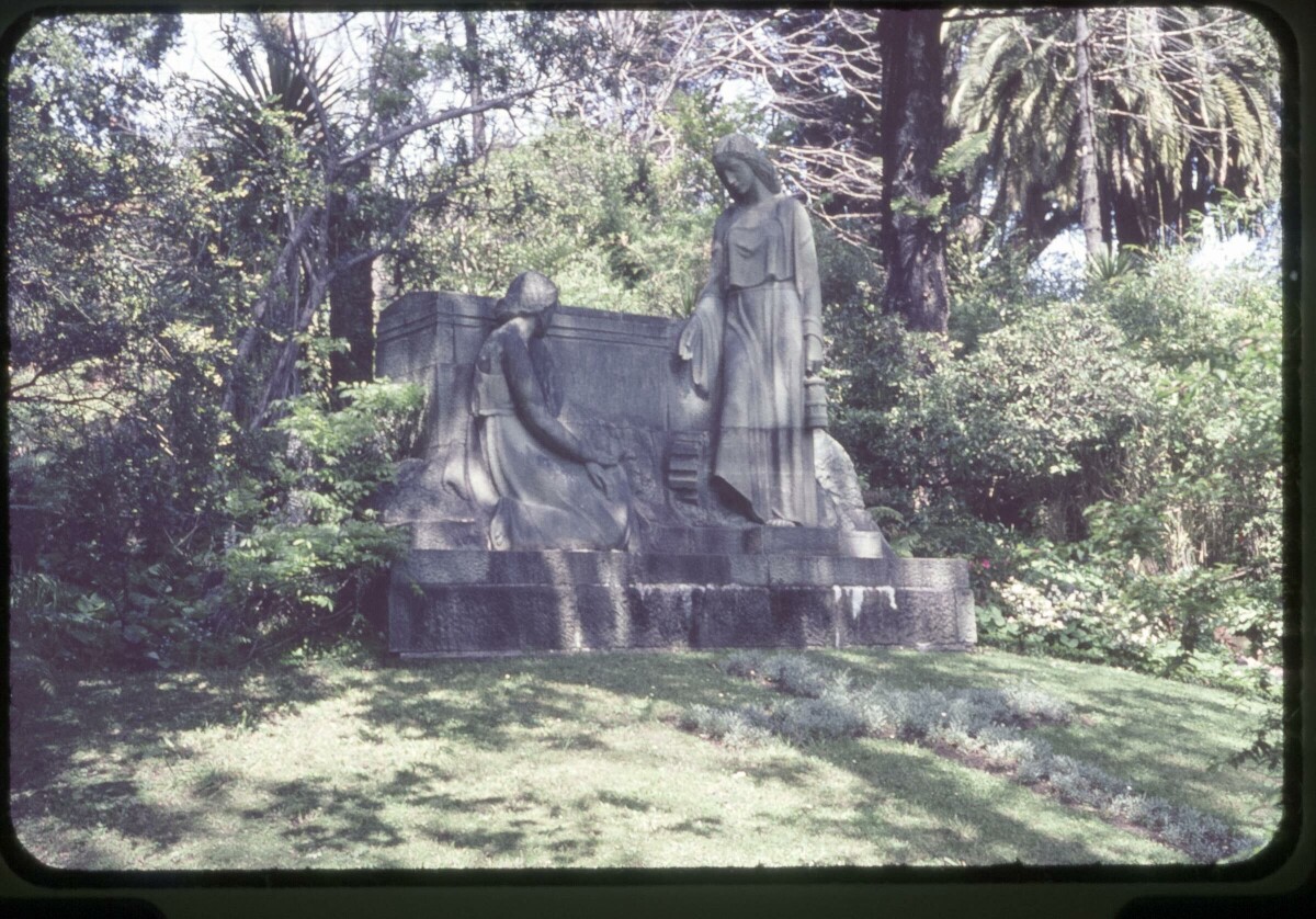 Plano entero de un monumento funerario con una cruz hecha con pasto en el suelo