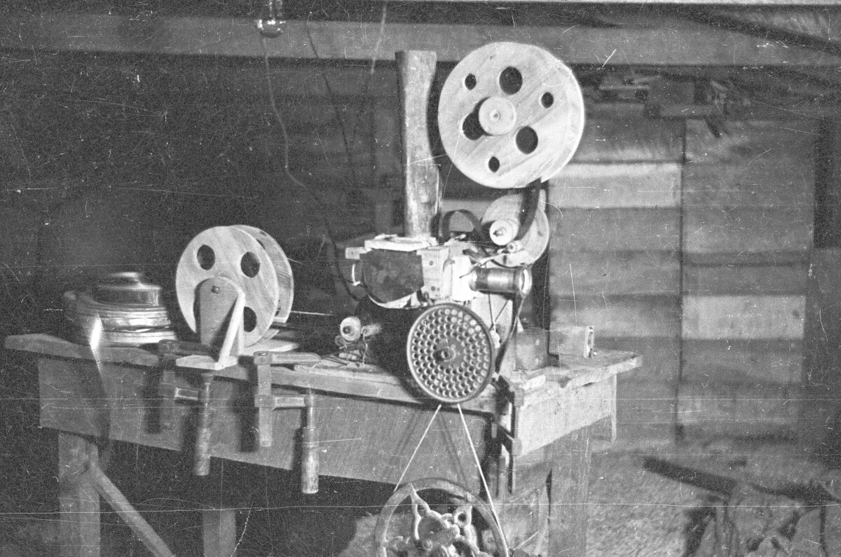 Plano entero de un proyector cinematográfico en el interior de una bodega