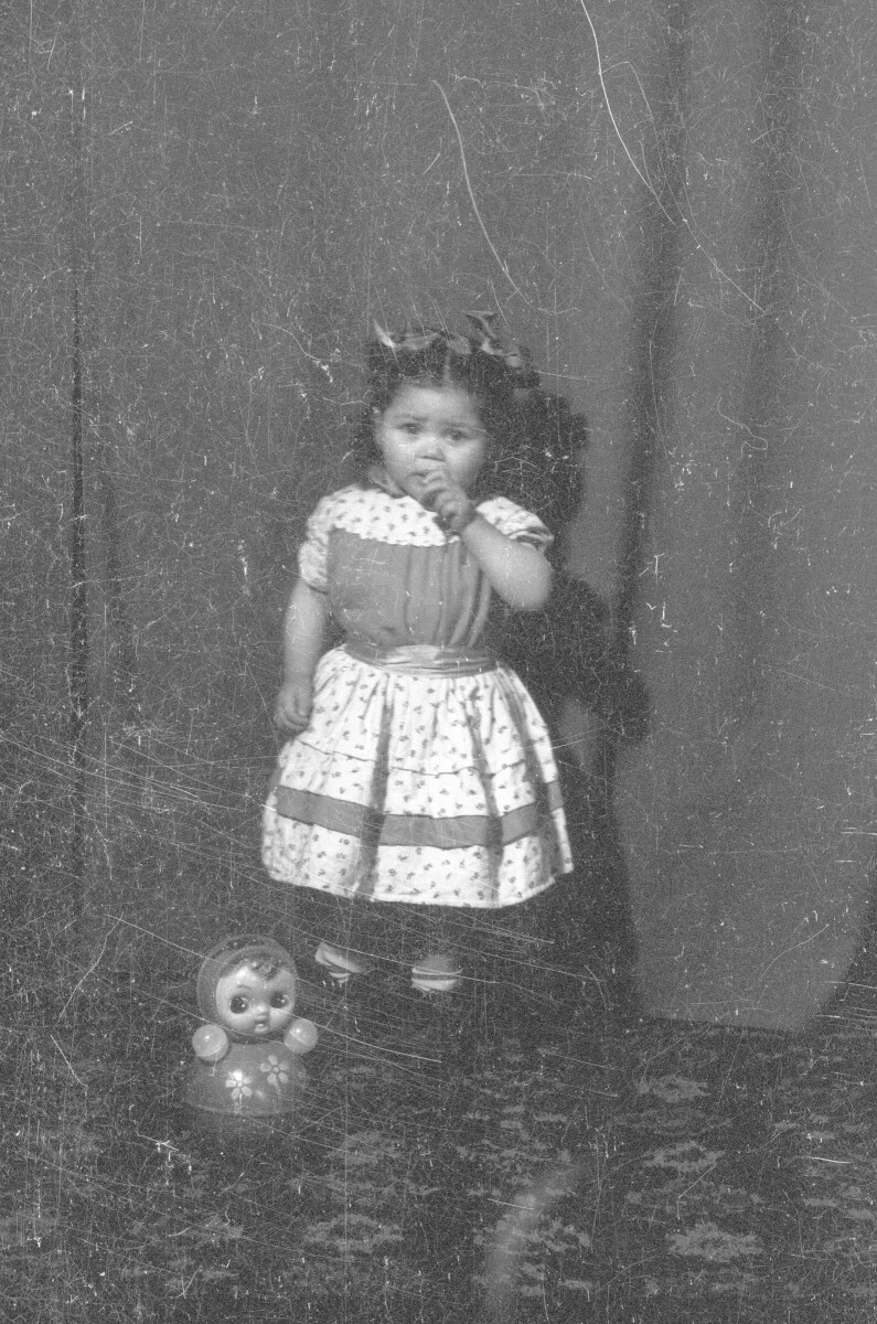 Retrato de estudio de Plano entero de una niña con Vestido posando parada junto a una muñeca