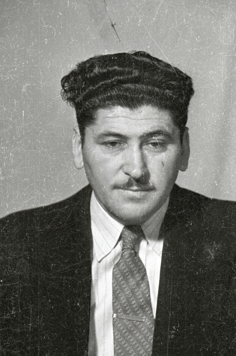 Retrato de estudio de Plano medio de un hombre de Traje posando de frente. Lleva puesto un pasador en la corbata