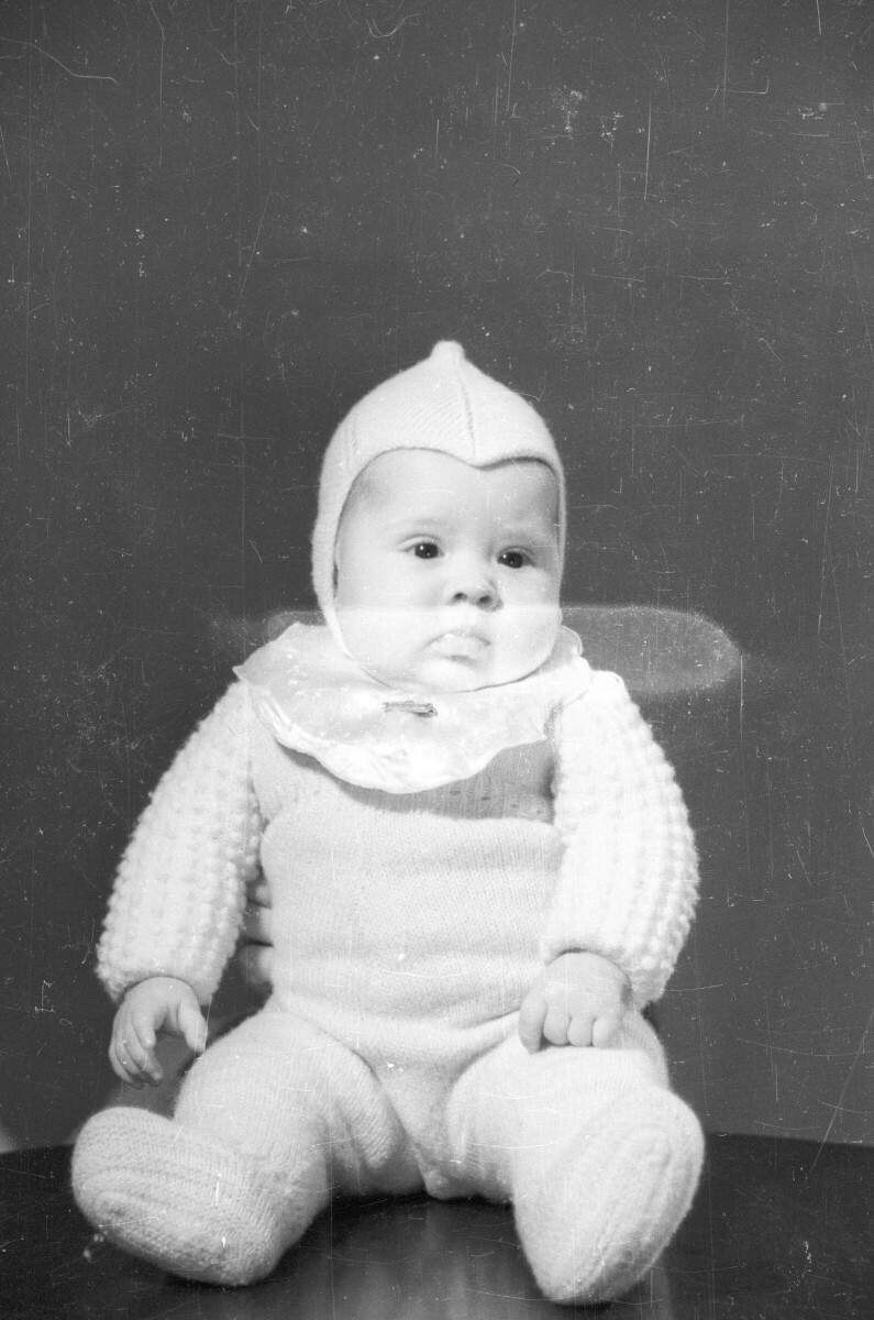 Retrato de estudio de Plano entero de Bebé con traje de lana sentado en una mesa posando de frente