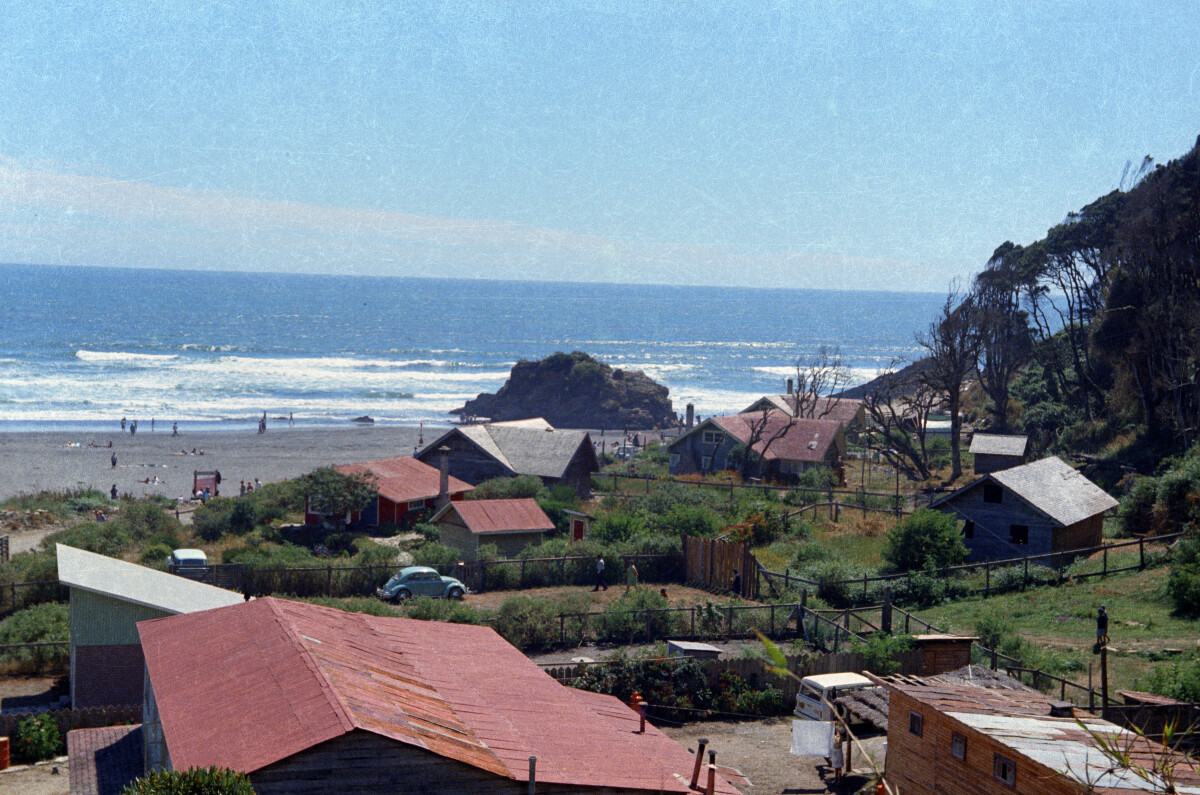 plano general de un grupo de casas de dos niveles ubicadas a los pies de un cerro con vista a la playa de Mehuín