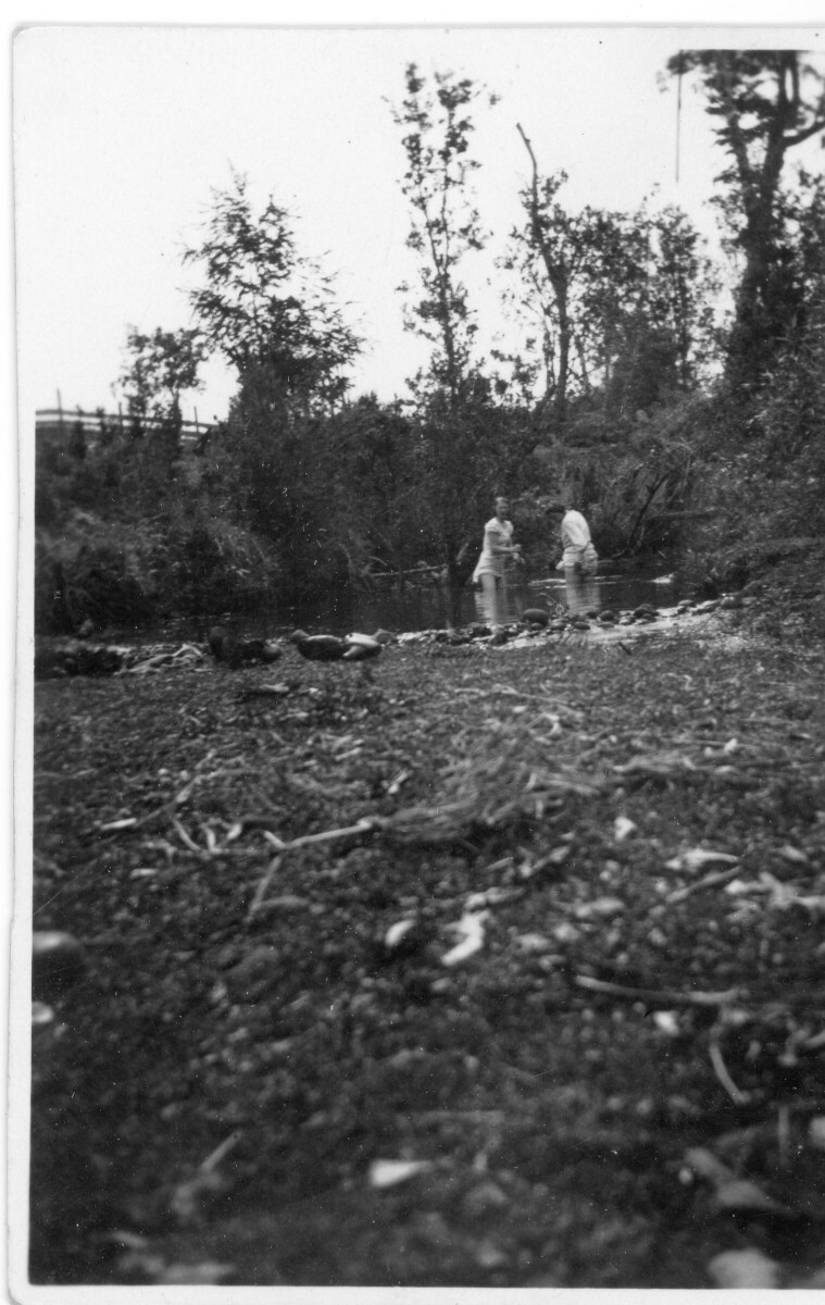 Plano general de dos mujeres bañándose en un río no identificado.