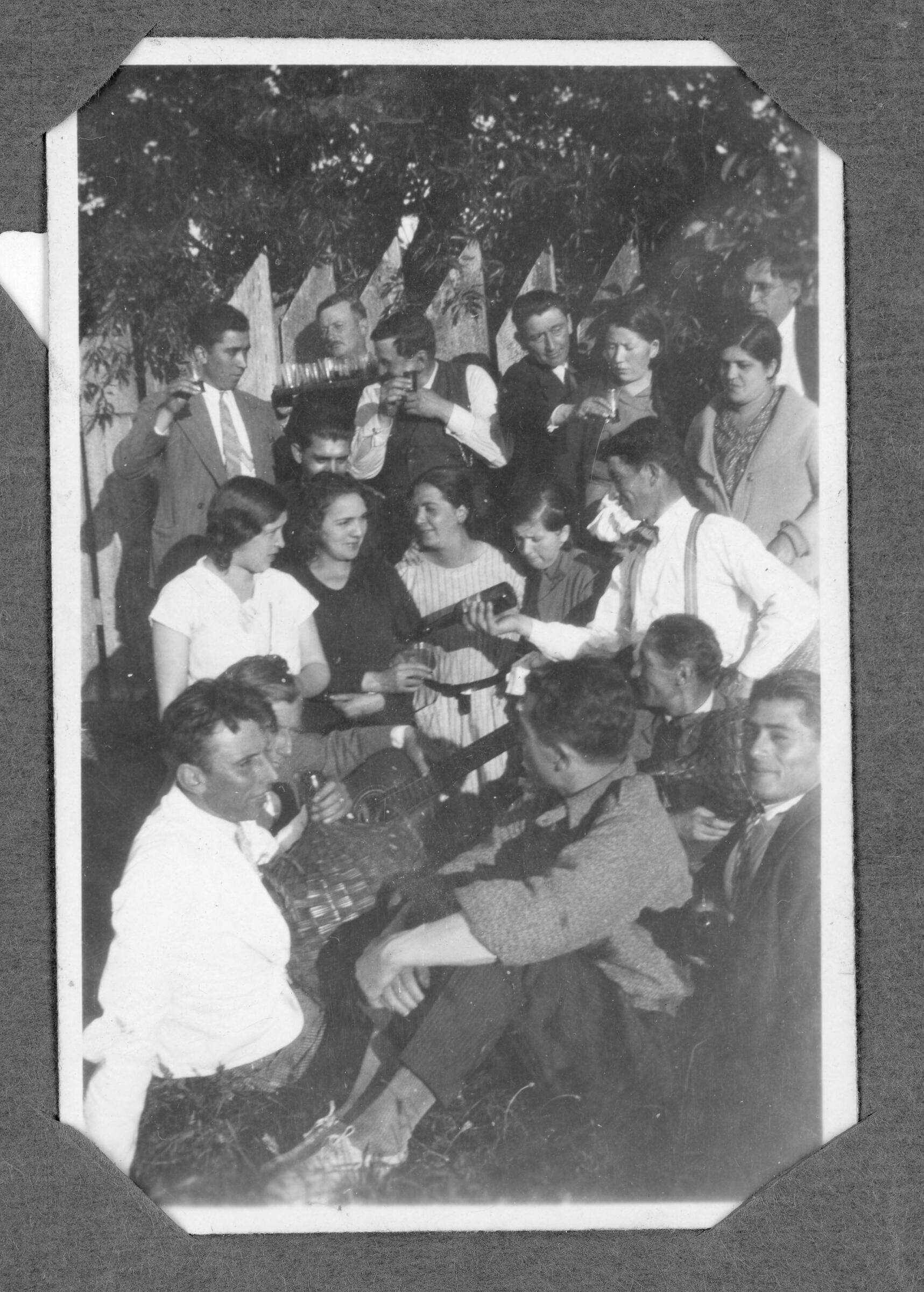Retrato grupal de la familia Figueroa en una celebración en Huequecura. Hay hombres adultos, mujeres adultas, niños y niñas. Algunas personas tienen instrumentos como guitarras y un acordeón, y hay una persona con una garrafa forrada en mimbre.