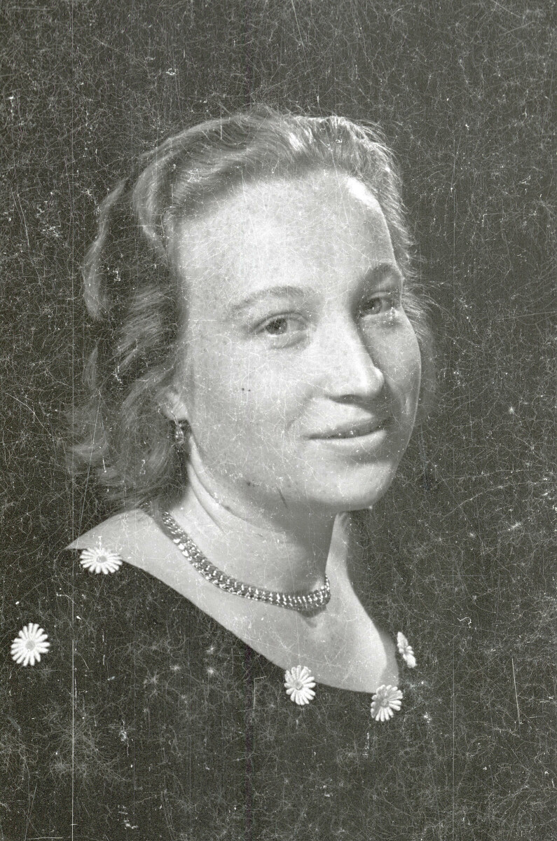 Retrato de estudio de Plano medio de una mujer joven posando sentada. Lleva puesto un Vestido con margaritas