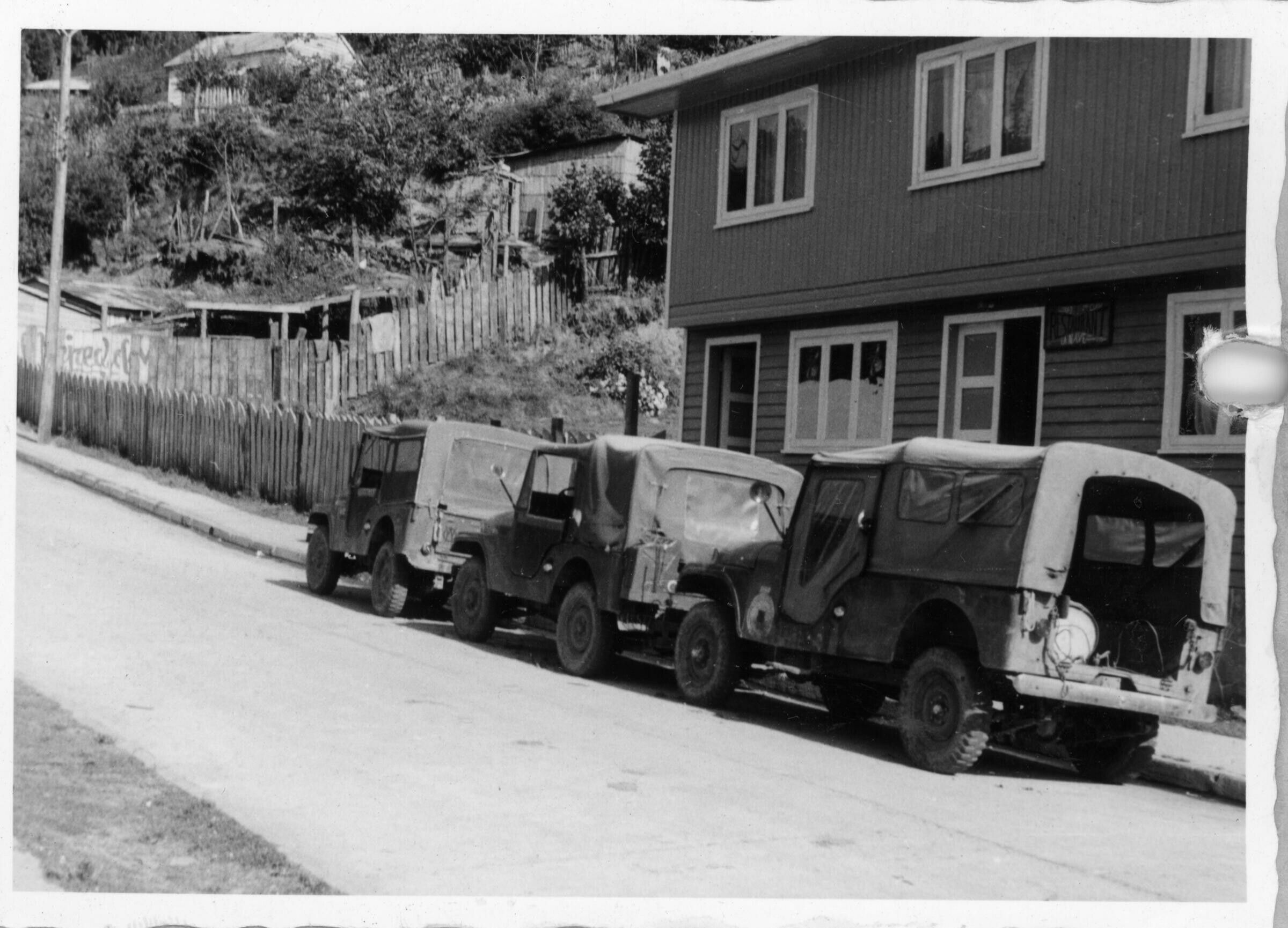 plano general de tres camionetas estacionadas en una cuesta, en el frontis de un restaurante durante un paseo realizado desde Hueicolla a Corral