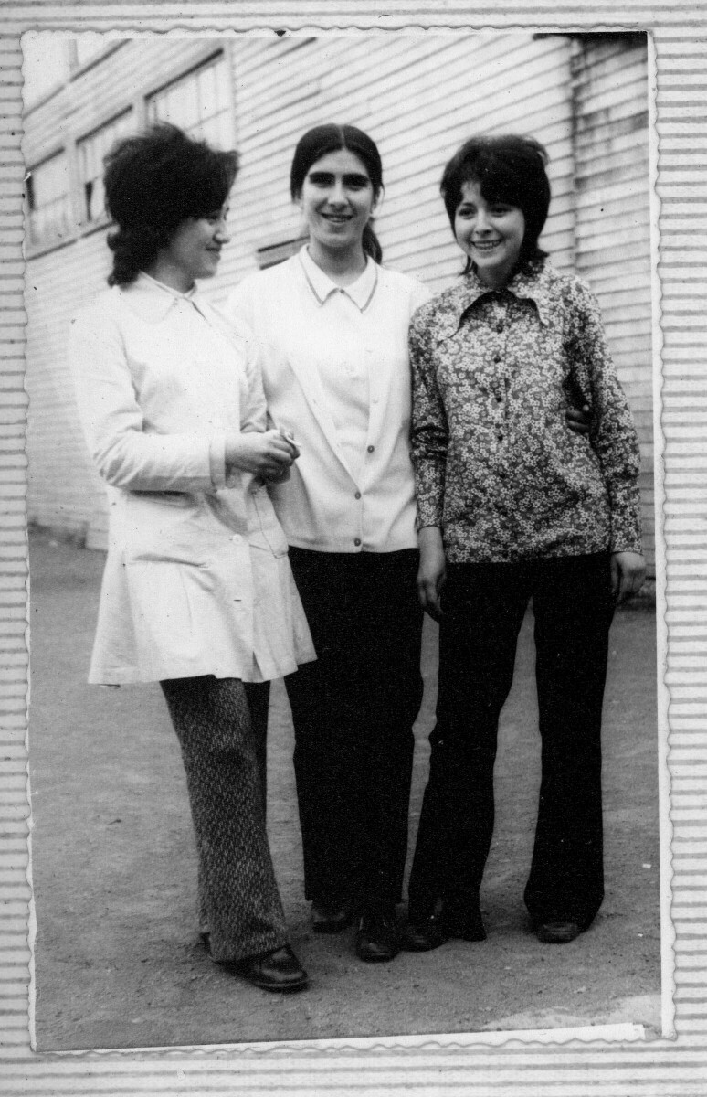 Retrato grupal de tres mujeres adultas. detrás, un inmueble