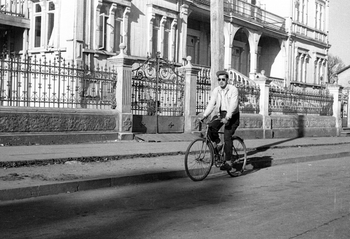 Hombre con Gafas Paseando en Bicicleta Camello por las Afueras del Ex Colegio de Cultura