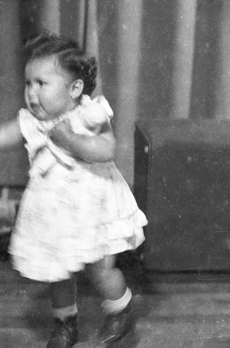 Plano entero de una niña de temprana edad, caminando por el estudio fotográfico