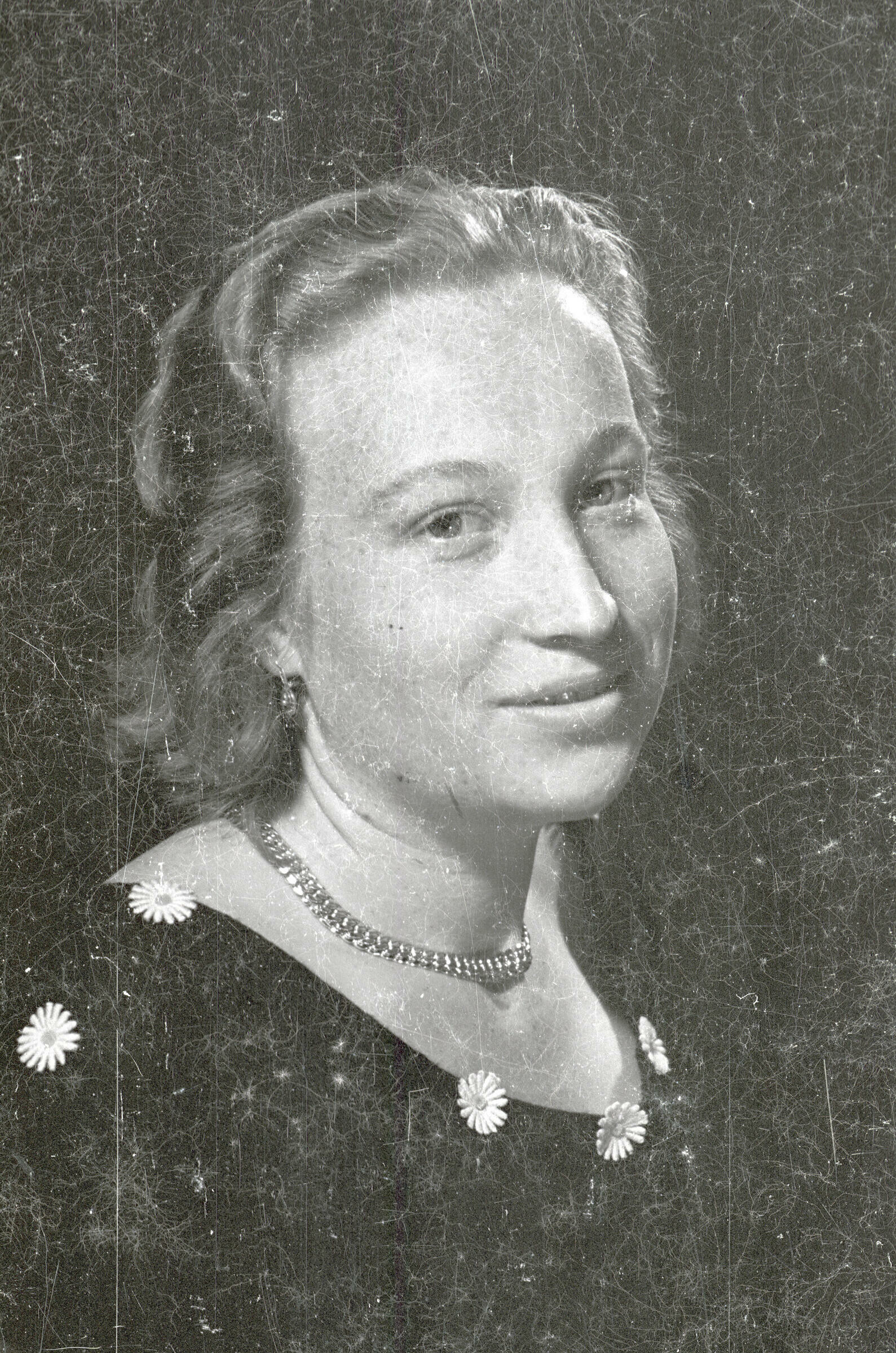 Retrato de estudio de Plano medio de una mujer joven posando sentada. Lleva puesto un Vestido con margaritas