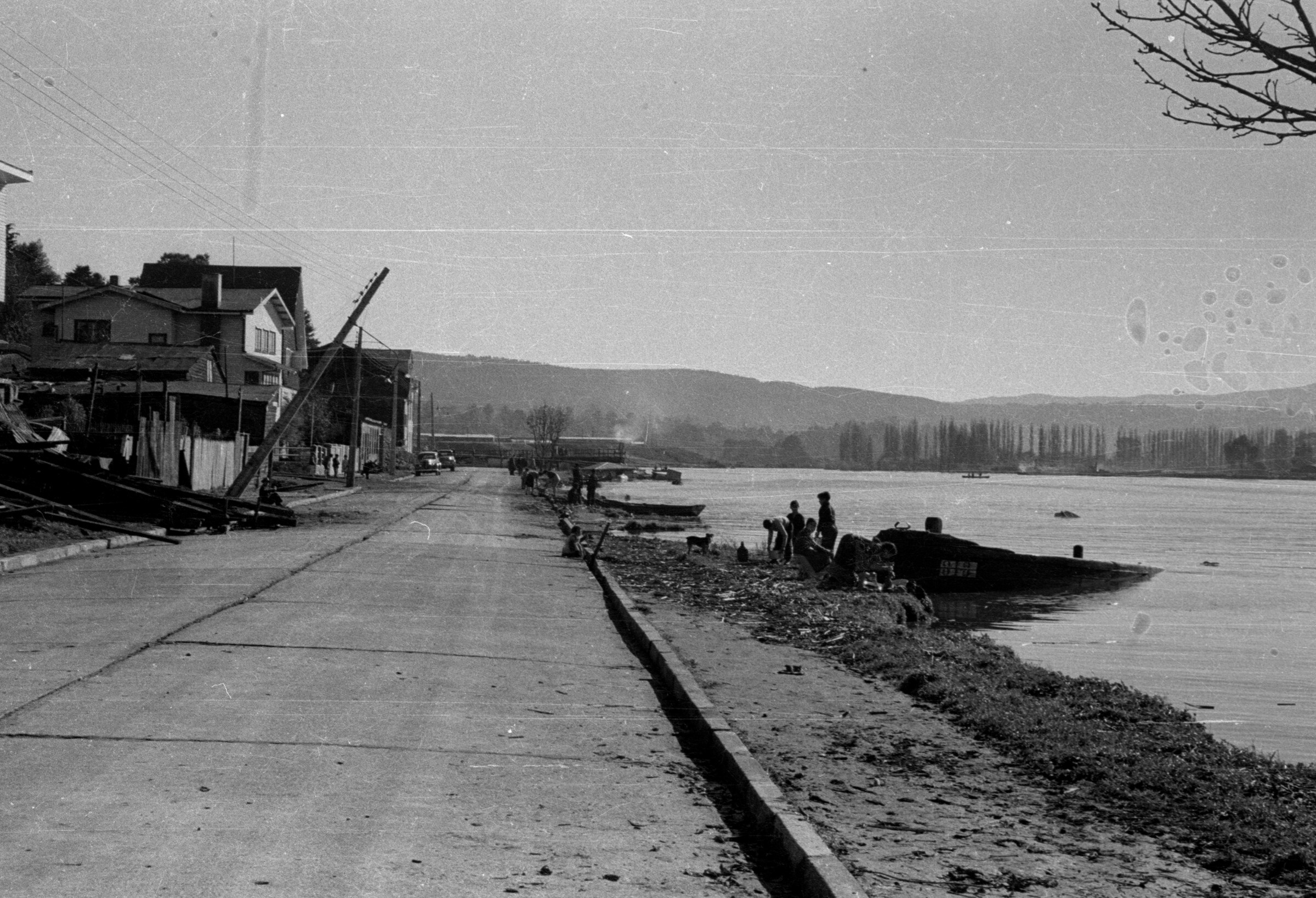 Grupo de Personas sentadas en la Costanera Valdiviana después del Terremoto del 60'