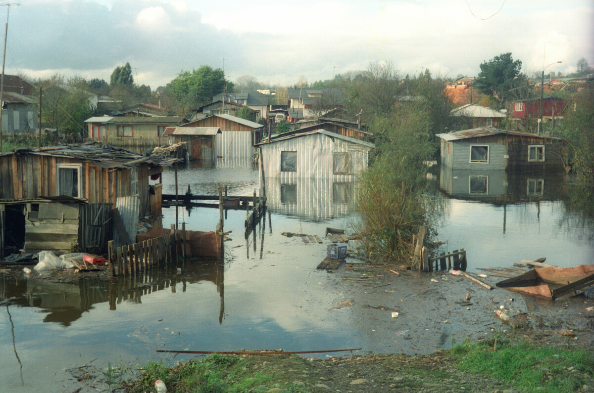 plano general de dos camionetas cruzando por la intersección de las calles Henríquez y Prat tras la inundación por el desbordamiento del río Llollelhue