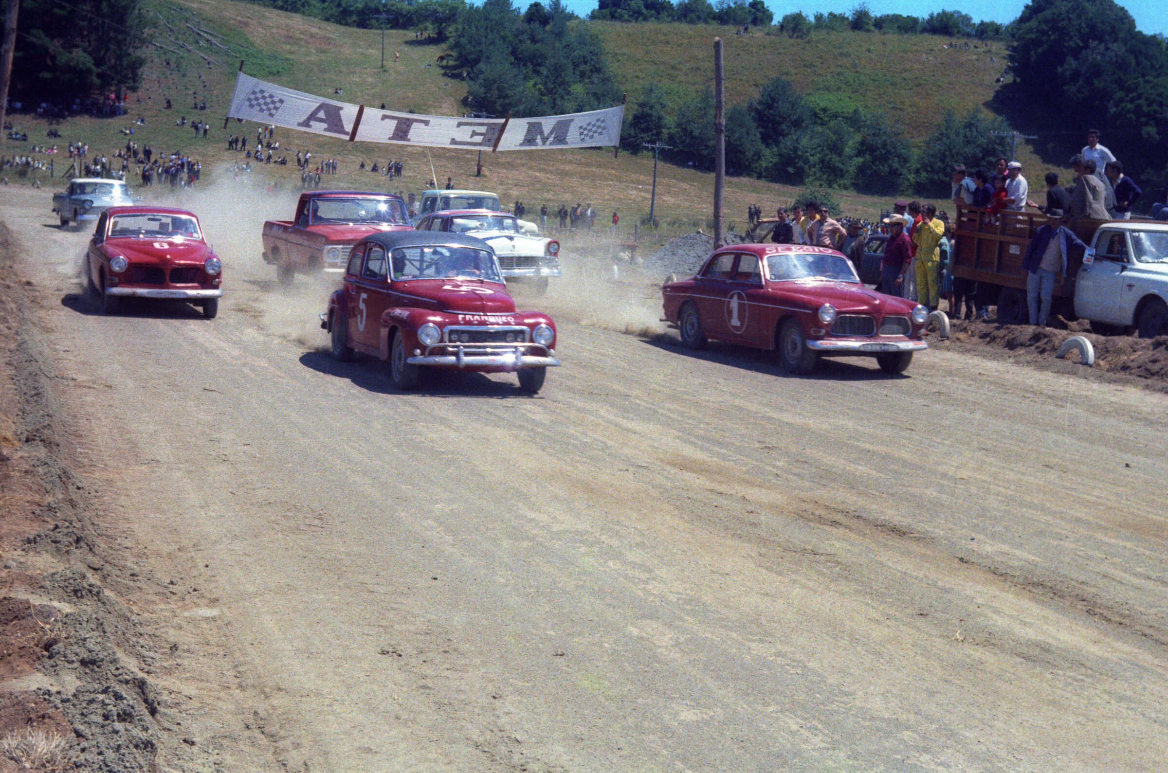 Plano general de un grupo de autos iniciando la carrera realizada en el autódromo de las vegas de Quilaco