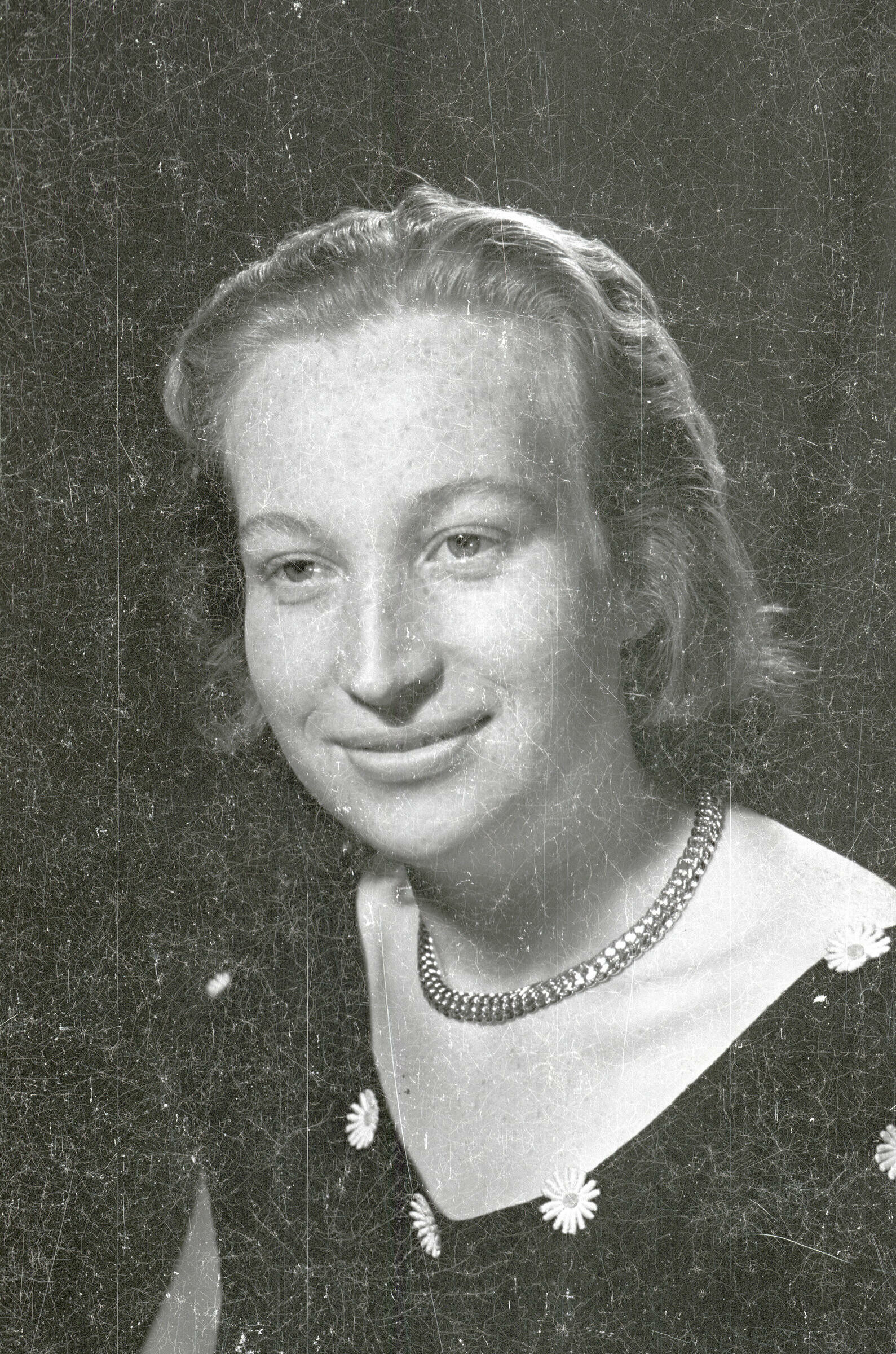 Retrato de estudio de Plano medio de una mujer joven posando sentada de Medio perfil. Lleva puesto un Vestido con margaritas