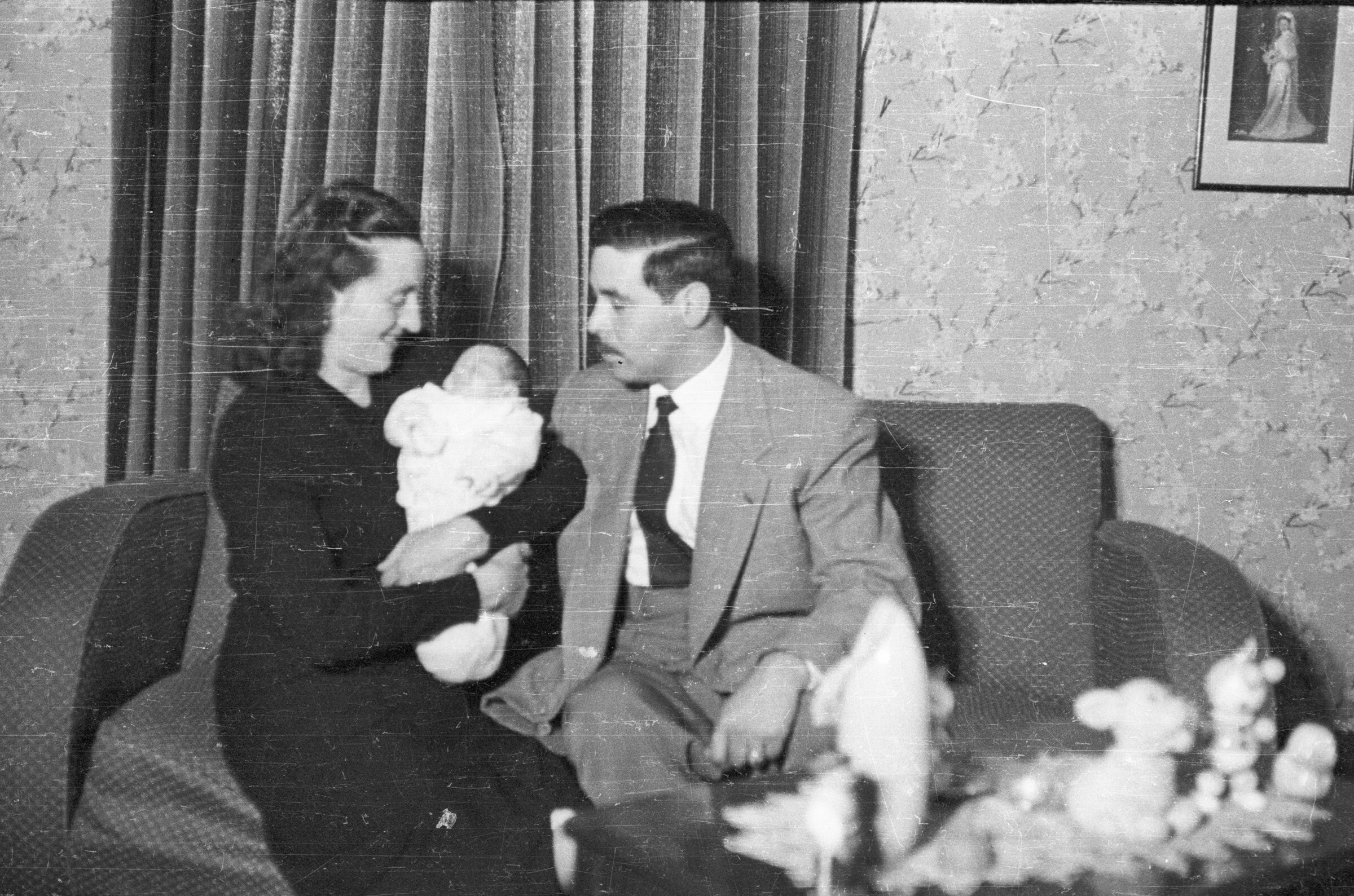 Retrato de plano entero de Roberto Espinoza, Guacolda Delgado junto a su hijo Luis Espinoza Delgado, sentados en un sillón.