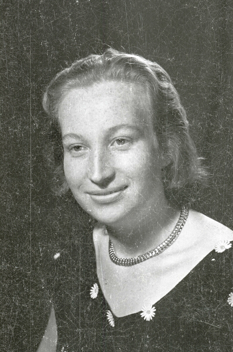 Retrato de estudio de Plano medio de una mujer joven posando sentada de Medio perfil. Lleva puesto un Vestido con margaritas