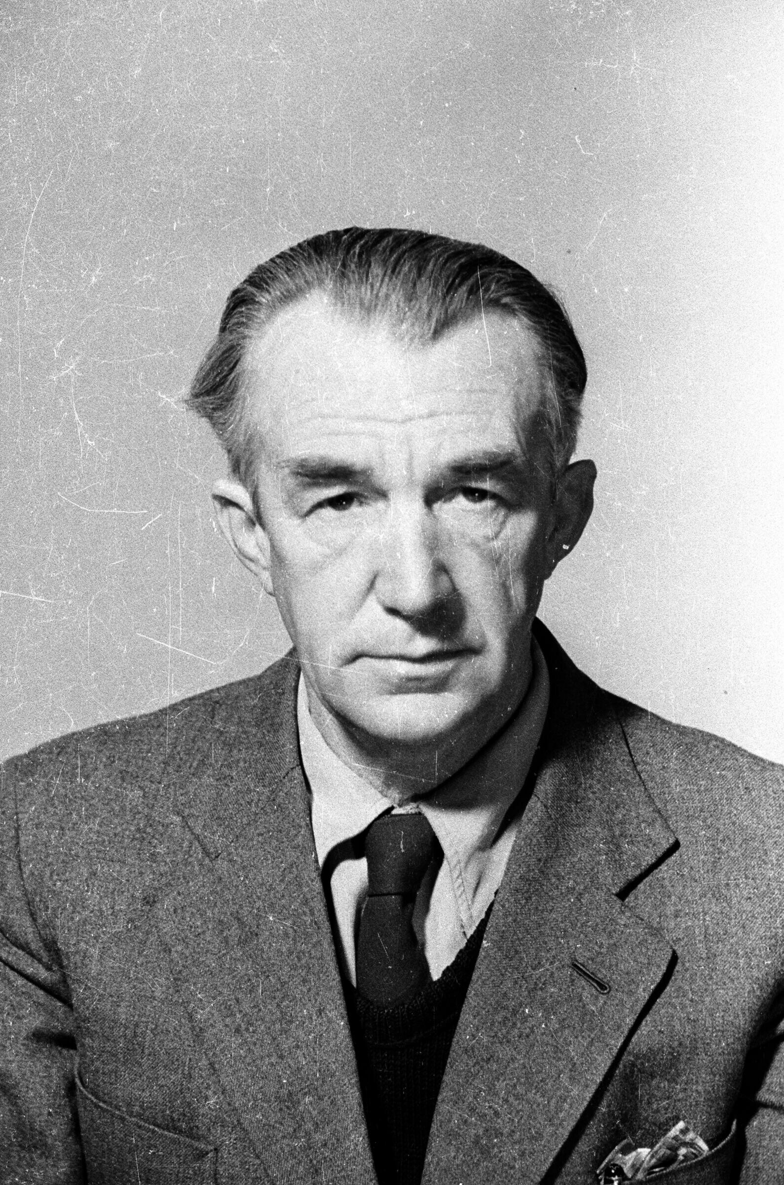 Retrato de estudio de Plano medio de un hombre mayor, vestido de Traje. Se encuentra posando de frente