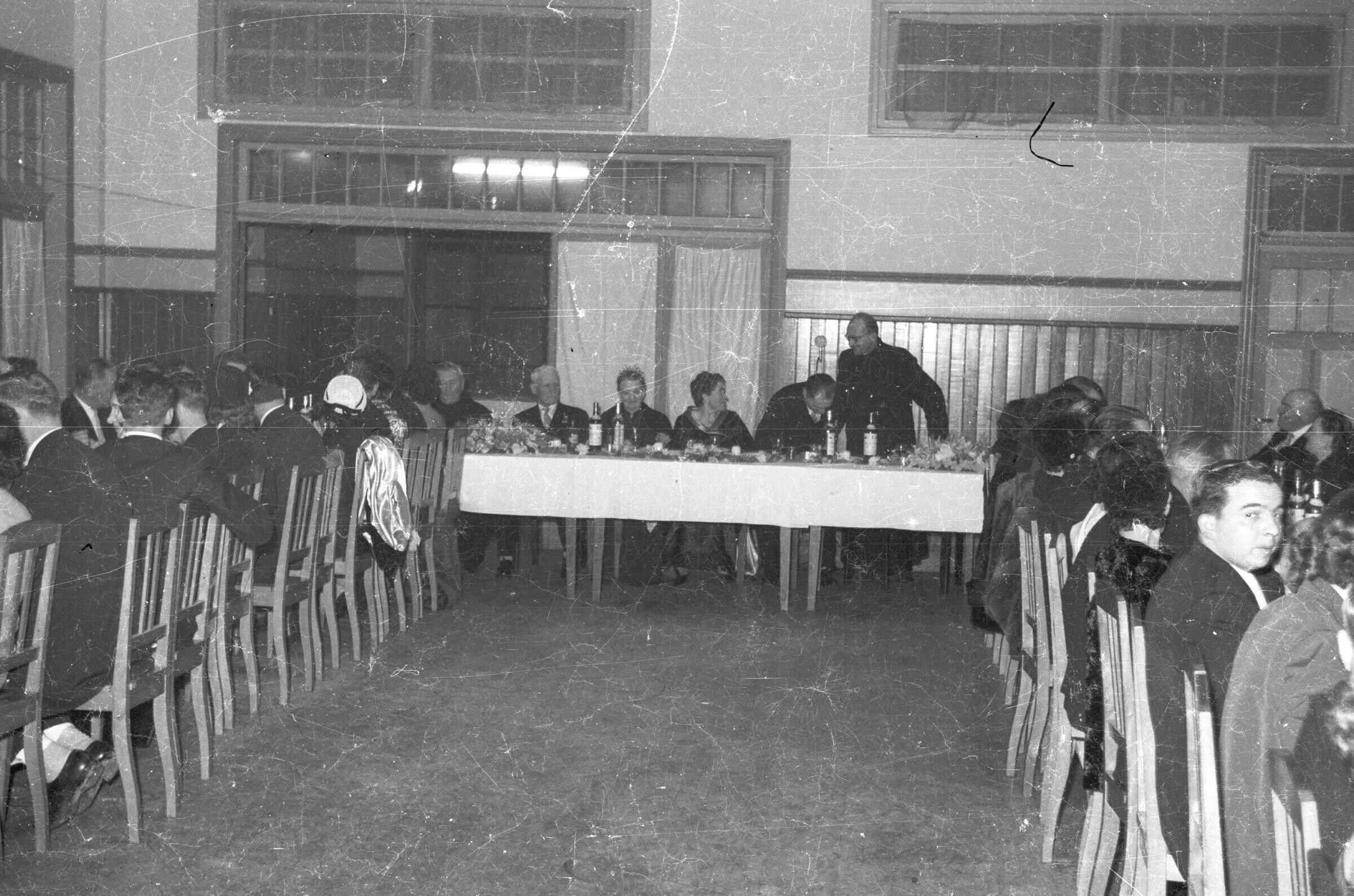 plano general de grupo de Hombres con Trajes y Mujeres con Vestidos alrededor de una mesa en un lugar no identificado