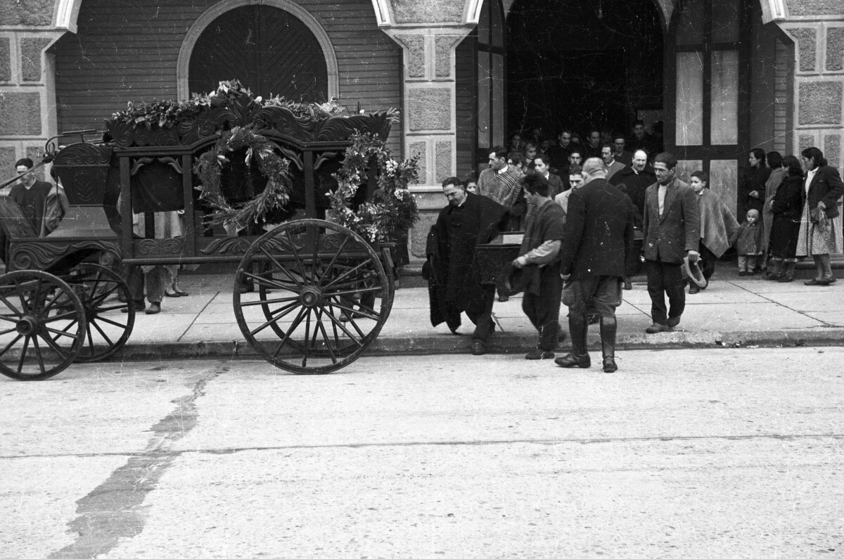 Plano entero de Hombres con Trajes sacando ataúd de iglesia para ponerla en carroza fúnebre
