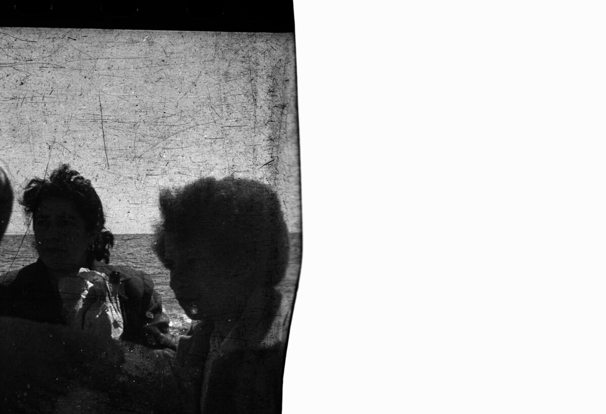 Reproducción de fotografía. Plano entero de tres mujeres viajando en el primer recorrido de un barco a vapor a la localidad de Hueicolla