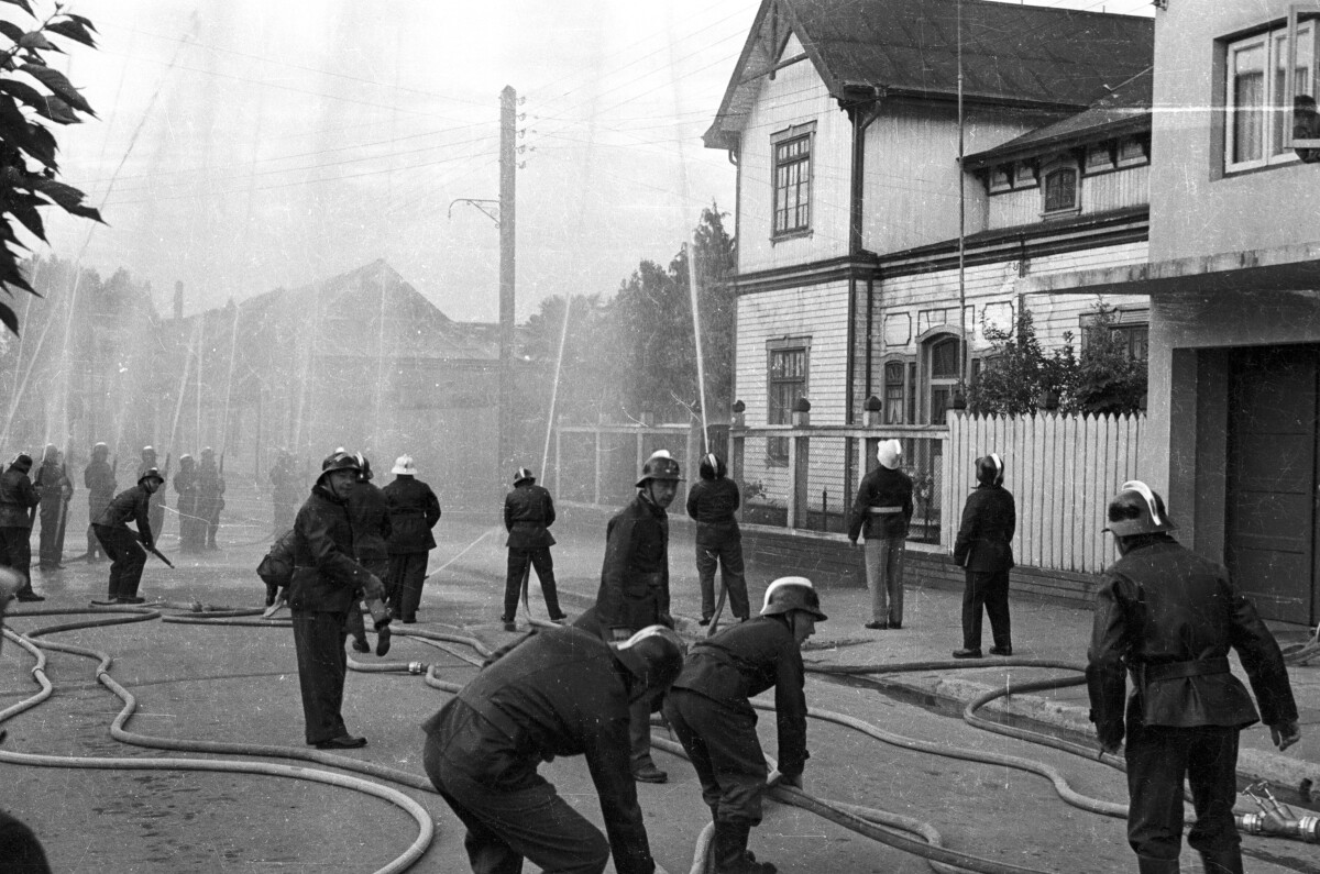 plano general de una compañía de bomberos realizando un procedimiento de entrenamiento lanzando agua hacia el cielo con sus mangueras en el frontis de una casa ubicada en la ciudad de La Unión