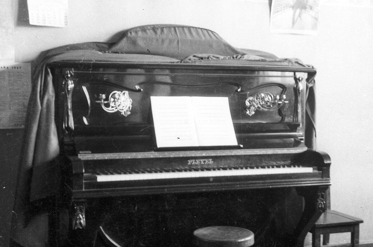 Plano entero de piano con partituras en escuela superior de niñas n°2