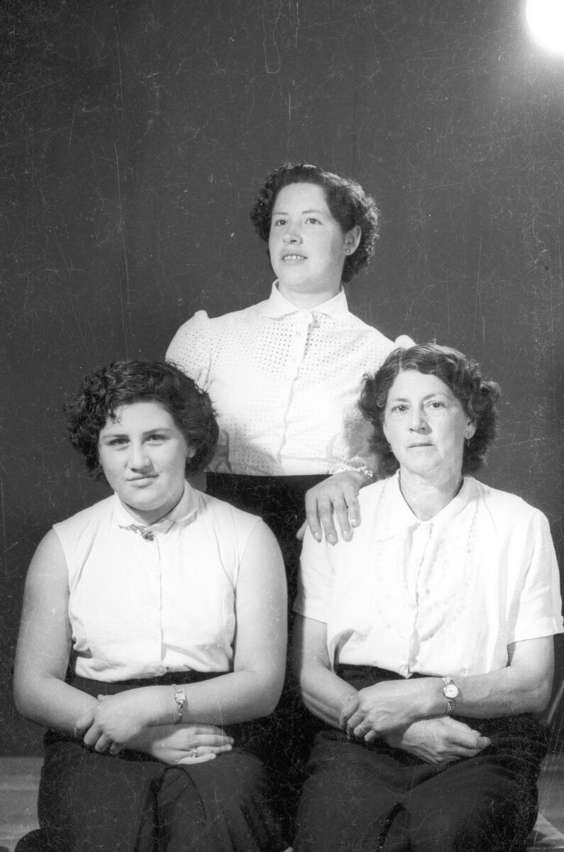 Retrato de estudio de Plano medio largo de tres mujeres posando. Dos se encuentran sentadas y una tercera está parada por detrás.