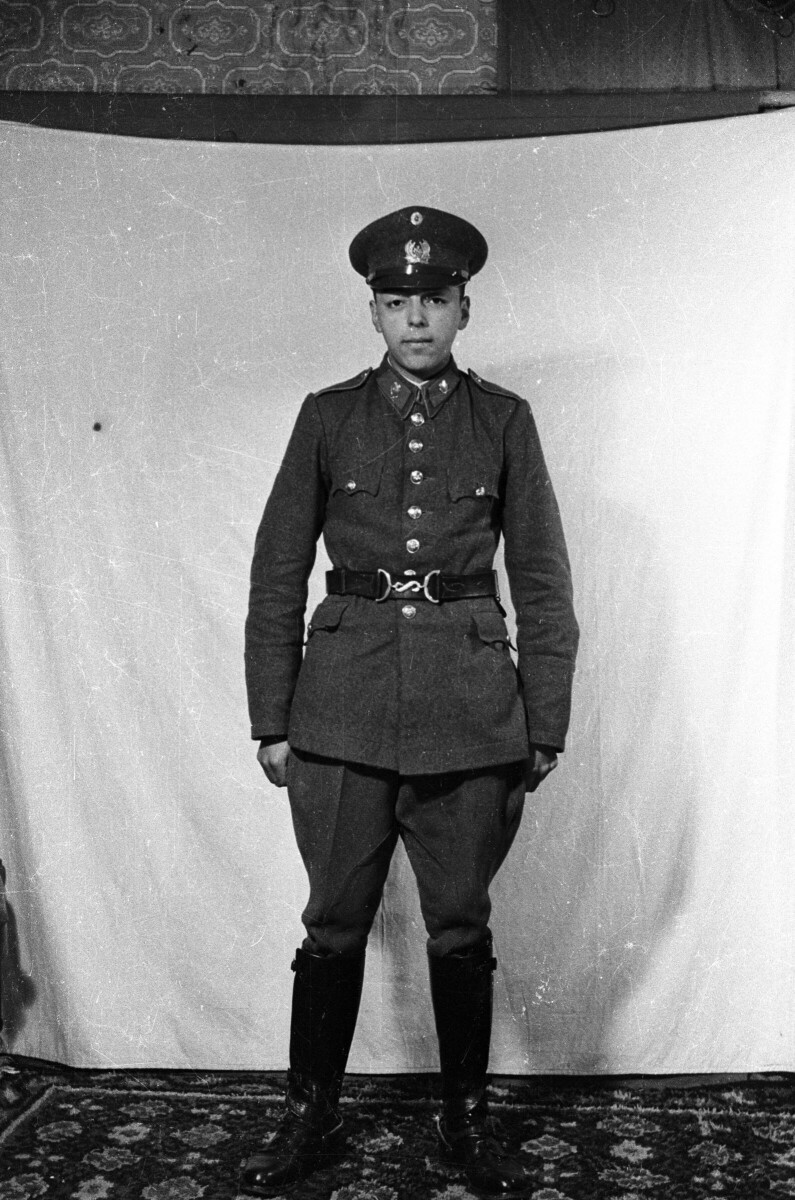 Retrato de estudio de Plano entero de un joven Carabinero posando de pie. Lleva puesto su uniforme
