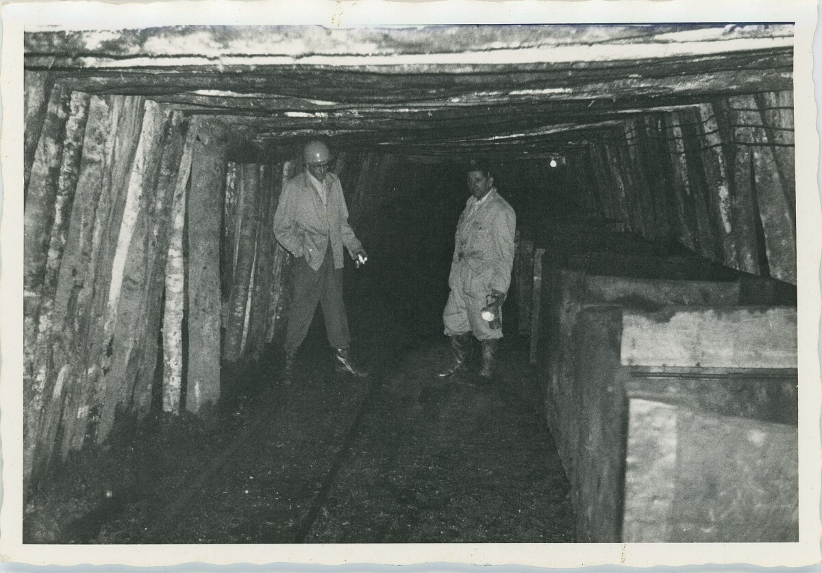 plano general de dos mineros conversando sobre los rieles en el interior de la mina Catamutún