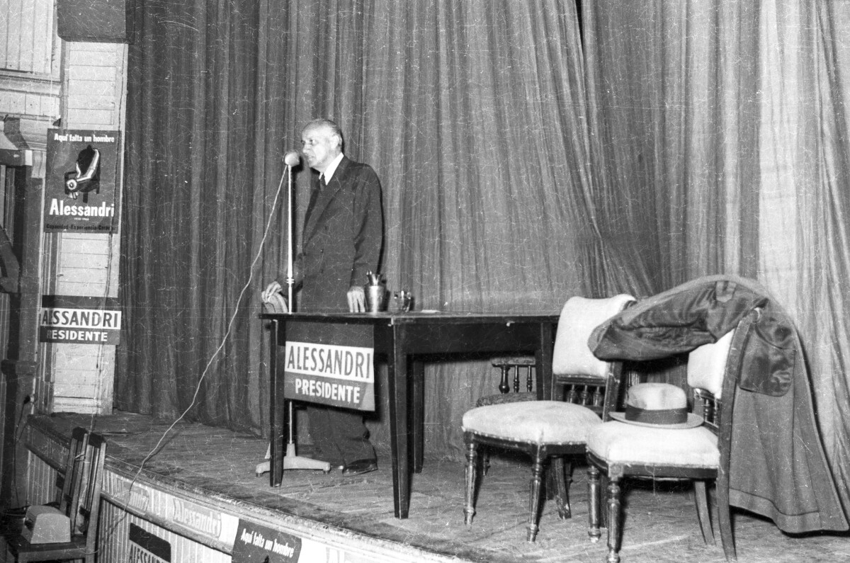 plano general de Jorge Alessandri dando un discurso sobre una tarima durante su candidatura presidencial realizada en la ciudad de La Unión