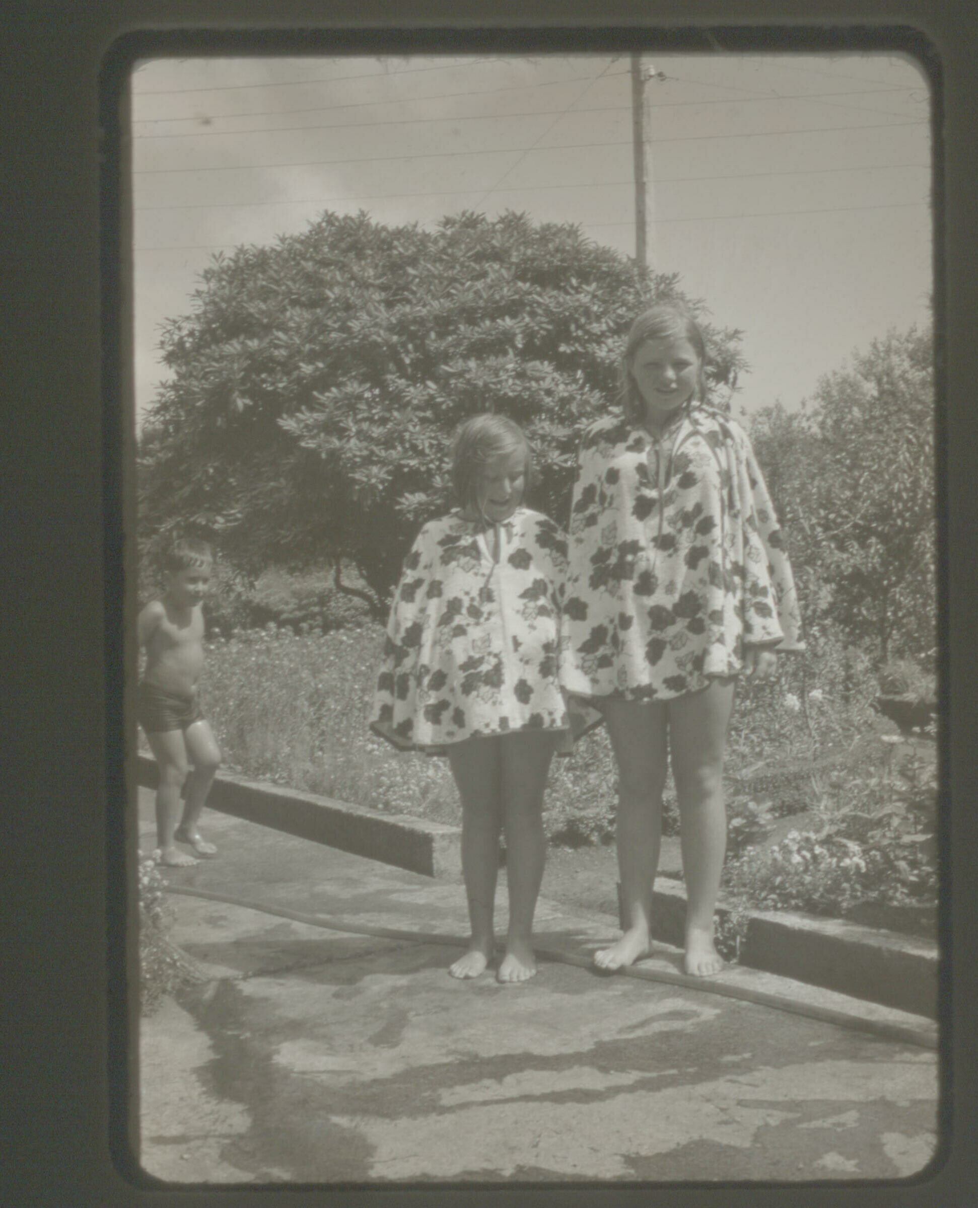 Retrato de plano entero de Yelly Carrasco junto a una niña, tapadas con una toalla con capucha