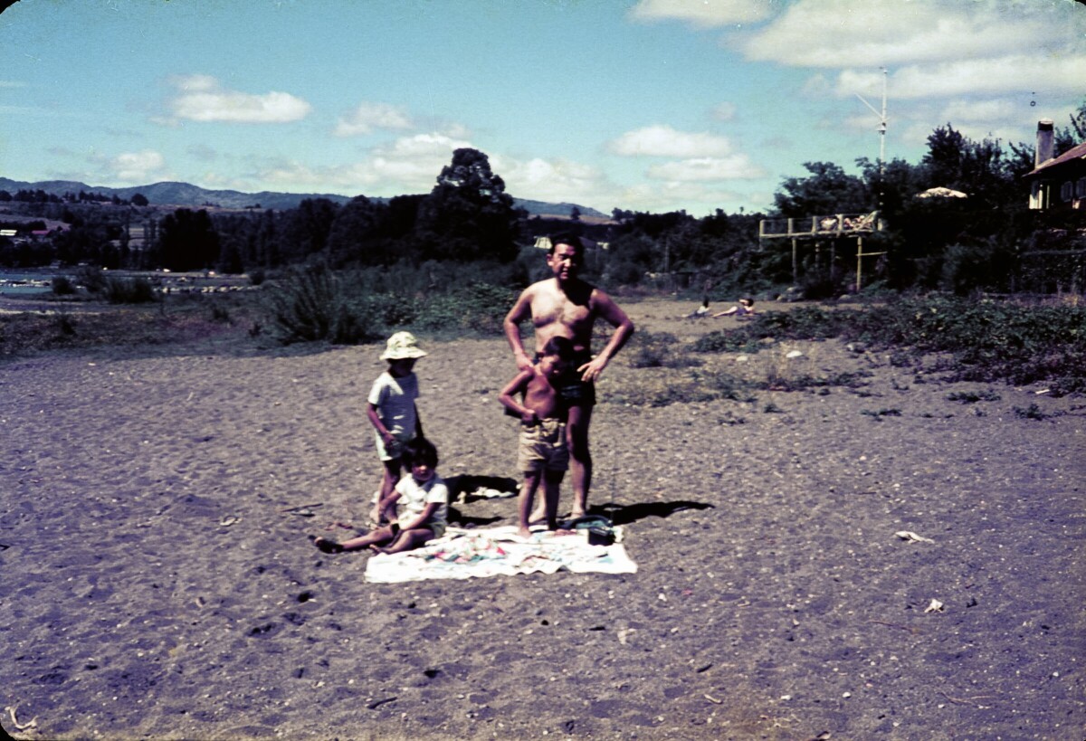 Retrato de plano entero de Hombre con Traje de baño junto a dos niñas y niño en una playa no identificada
