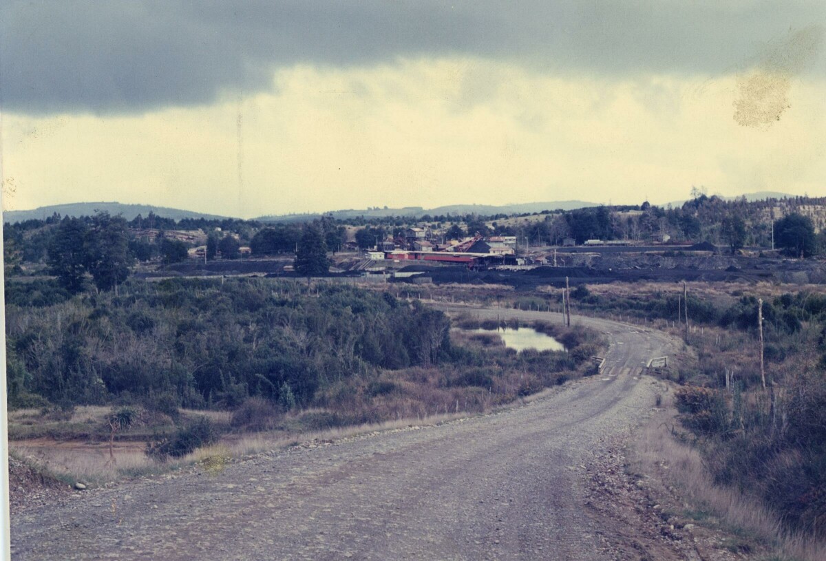 plano general de un camino de ripio no identificado. En el fondo se observan galpones y cerros del sector de la Compañía carbonífera San Pedro de Catamutún