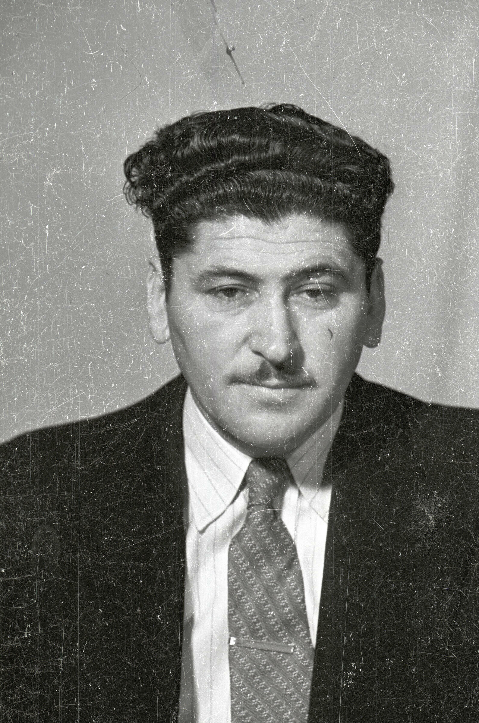 Retrato de estudio de Plano medio de un hombre de Traje posando de frente. Lleva puesto un pasador en la corbata