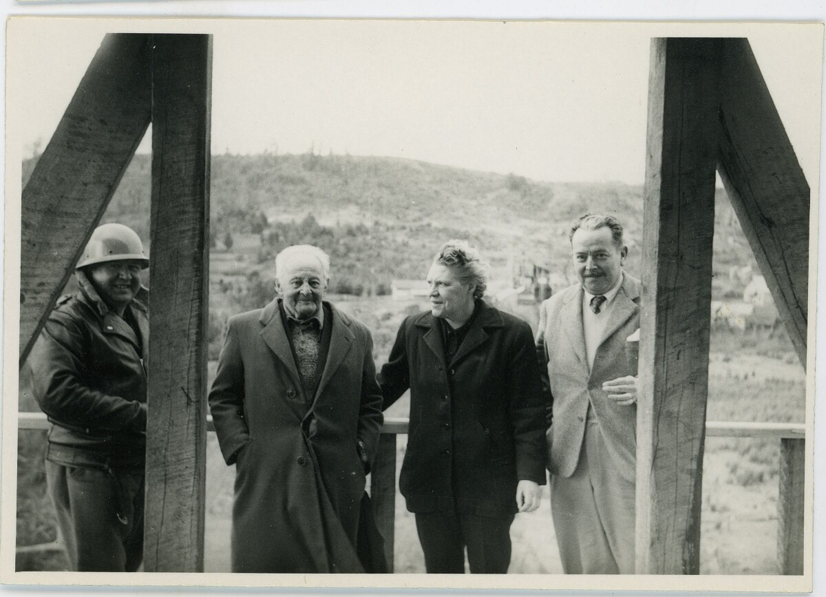 plano general de Olga Boettcher reunida con tres hombres, en el interior de una infraestructura no identificada en construcción. La fotografía fue tomada durante la visita de la gobernadora a la mina de Catamutún