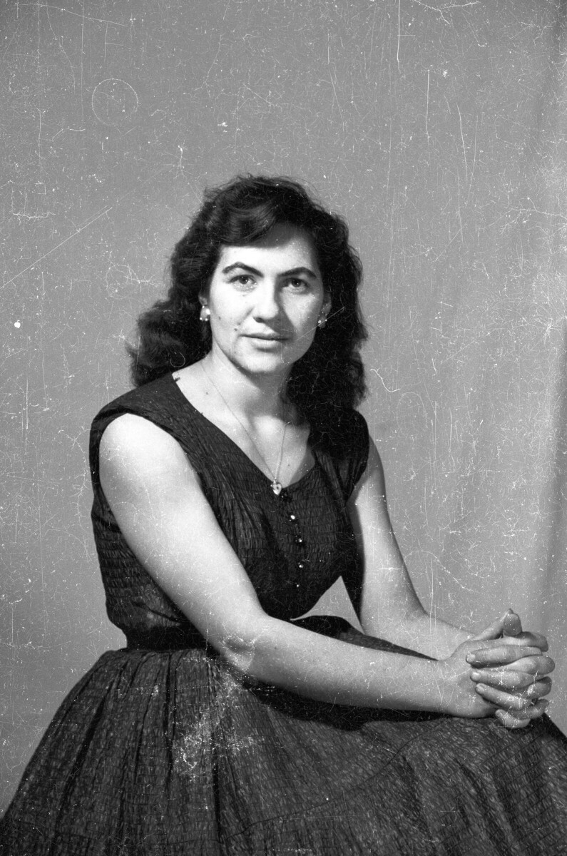 Retrato de estudio Plano americano de Mujer con Vestido sentada de Medio perfil con las manos en las rodillas, mirando de frente