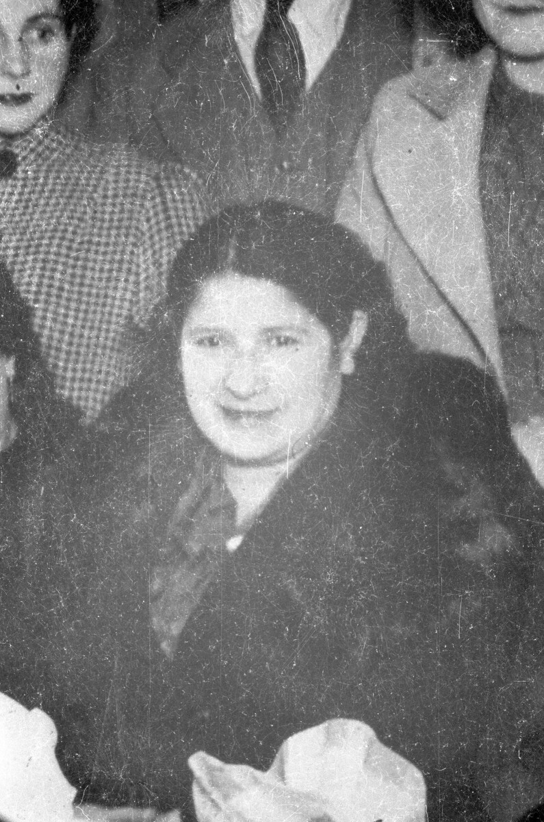 Retrato de plano medio de una mujer con abrigo posando entre un grupo de personas